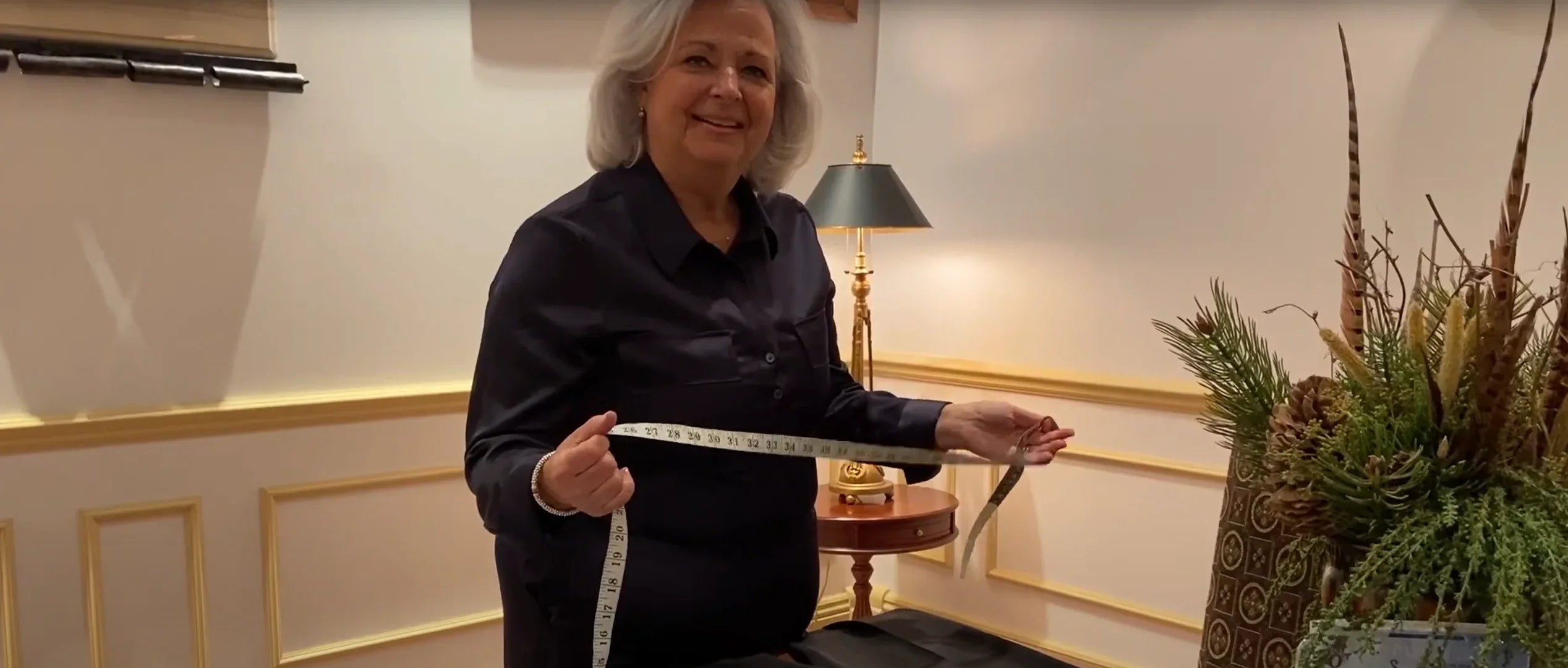 Senior woman measuring adaptive pants with tape measure, Ovidis Adaptive Wear demonstration