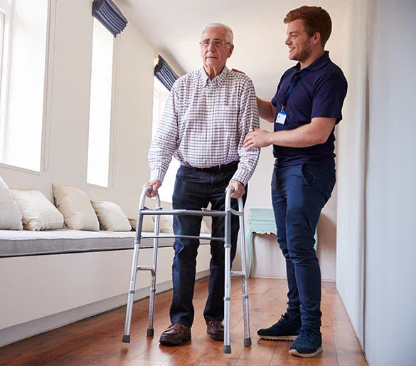 Caregiver assisting senior man with walker in bright, accessible home setting