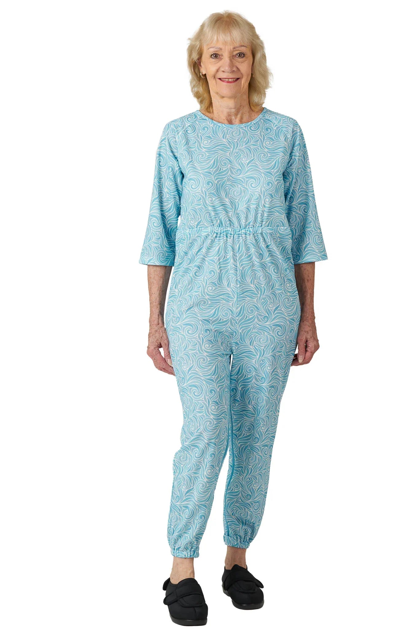 Senior woman wearing Ovidis adaptive anti-strip Alzheimer's jumpsuit in blue swirl pattern