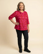 Senior woman wearing Ovidis adaptive fuchsia floral top with bow neckline detail, easy dressing