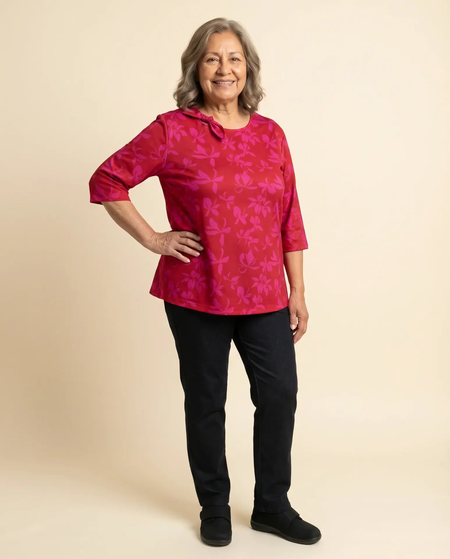 Senior woman wearing Ovidis adaptive fuchsia floral top with bow neckline detail, easy dressing