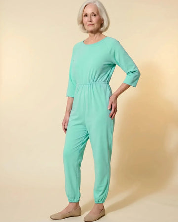 Senior woman wearing Ovidis adaptive Carrie Green jumpsuit, full body front view