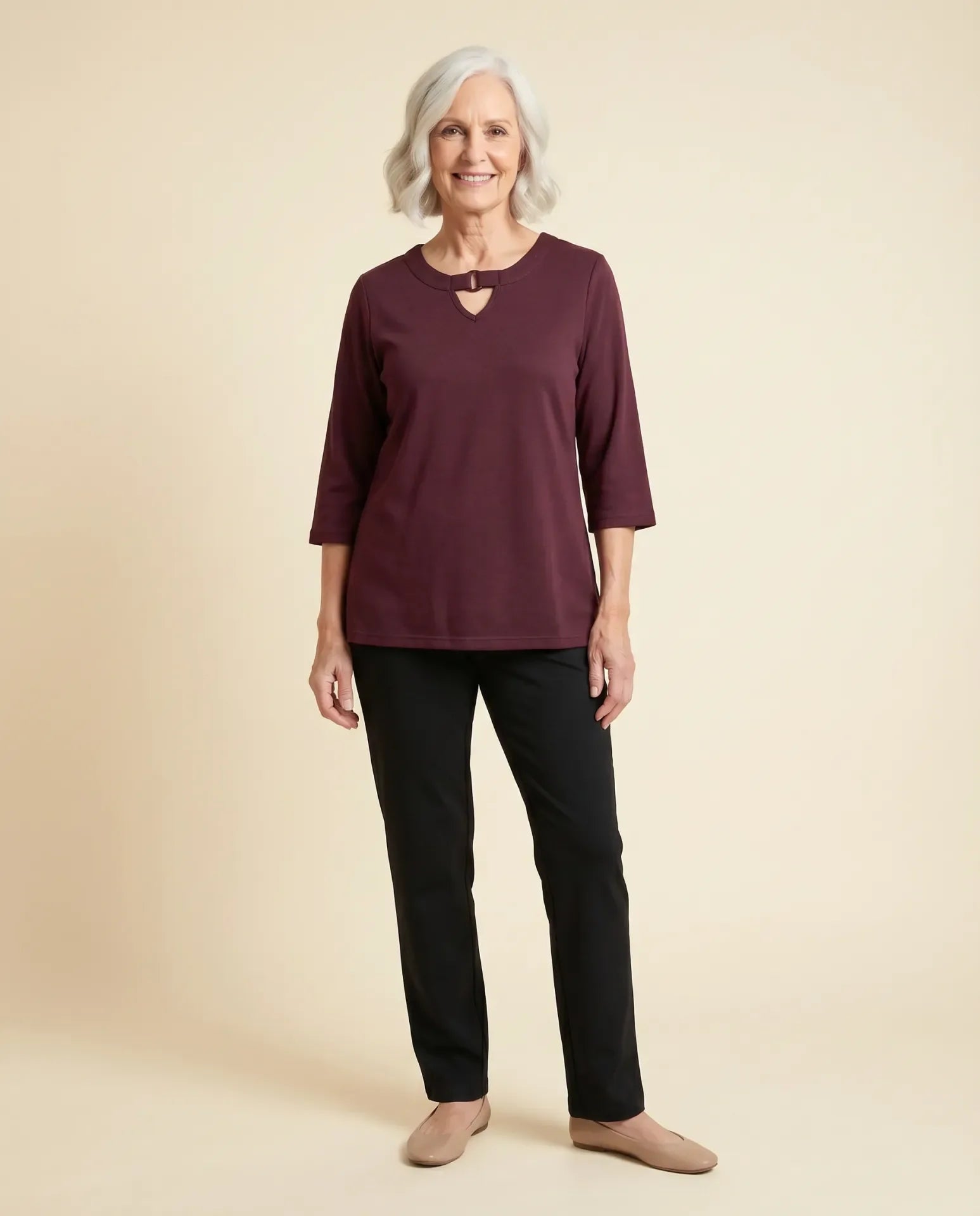 Senior woman wearing adaptive burgundy knit top with keyhole ring neckline detail, paired with black pants