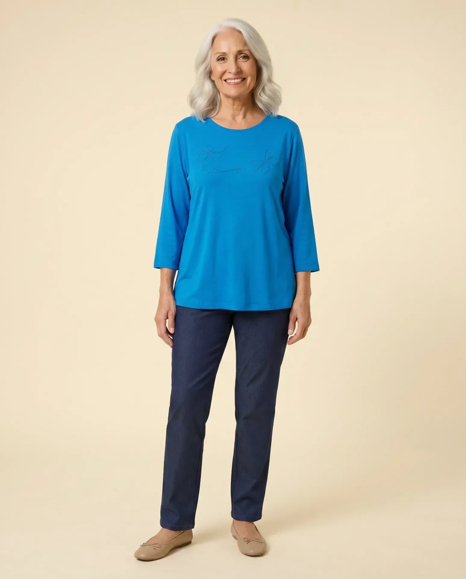 Senior woman wearing Ovidis adaptive sky blue top with butterfly appliqué, easy dressing for seniors