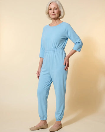 Senior woman wearing Ovidis adaptive Carrie Blue jumpsuit, full body front view