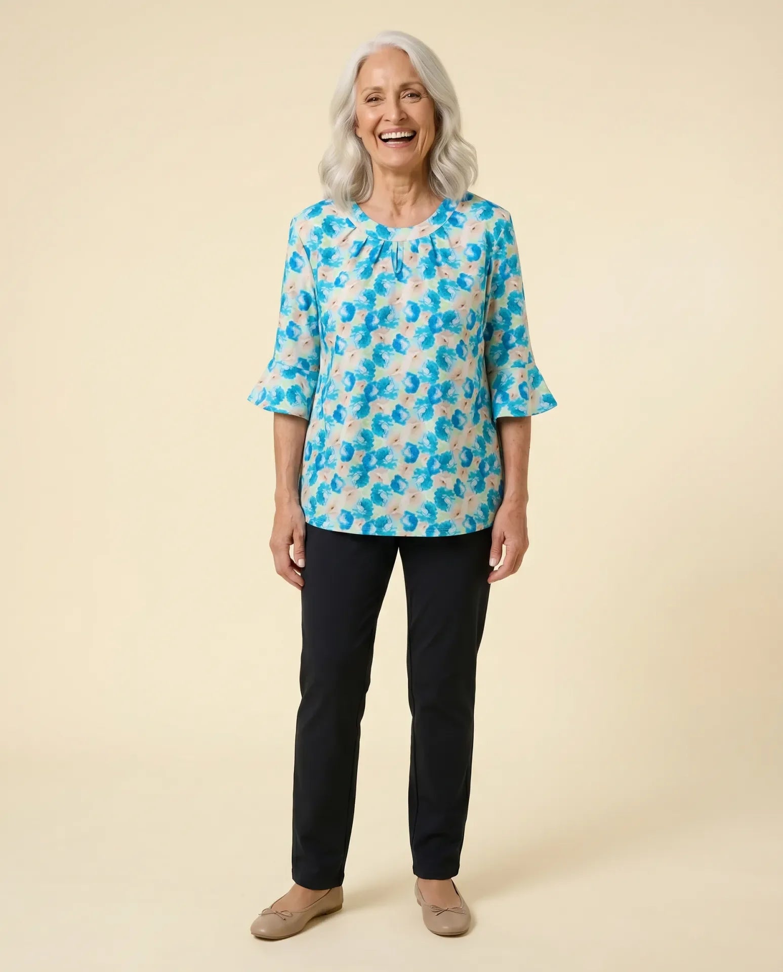 Senior woman wearing Ovidis adaptive blue floral bell sleeve top with pleated keyhole neckline, easy dressing