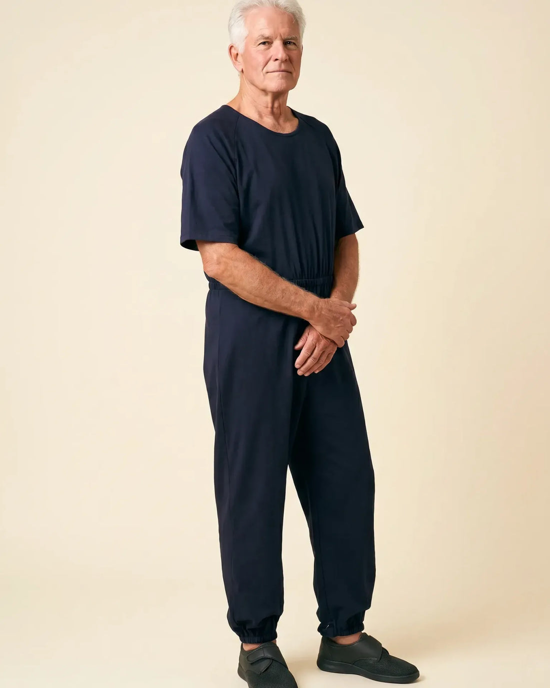 Senior man wearing Ovidis adaptive Bobby Navy jumpsuit, full body front view