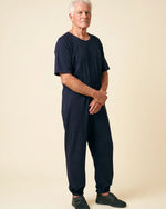 Senior man wearing Ovidis adaptive Bobby Navy jumpsuit, full body front view