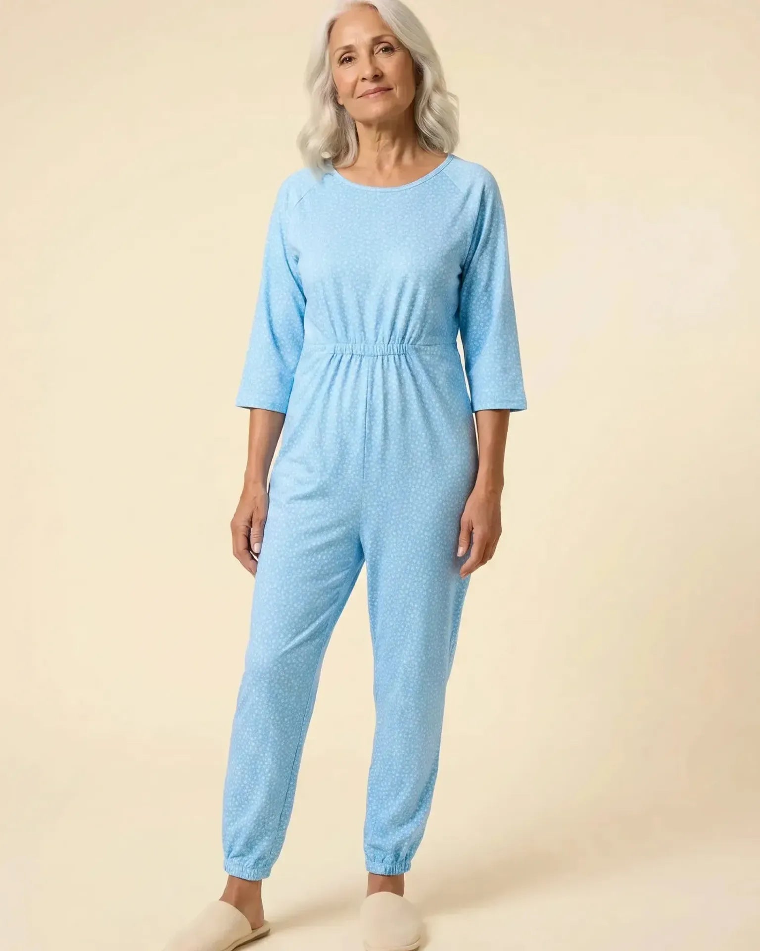 Senior woman wearing Ovidis adaptive Carrie Sky jumpsuit, full body front view