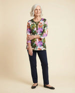 Senior woman wearing Ovidis adaptive olive botanical floral top with contrast Y-insert, easy dressing