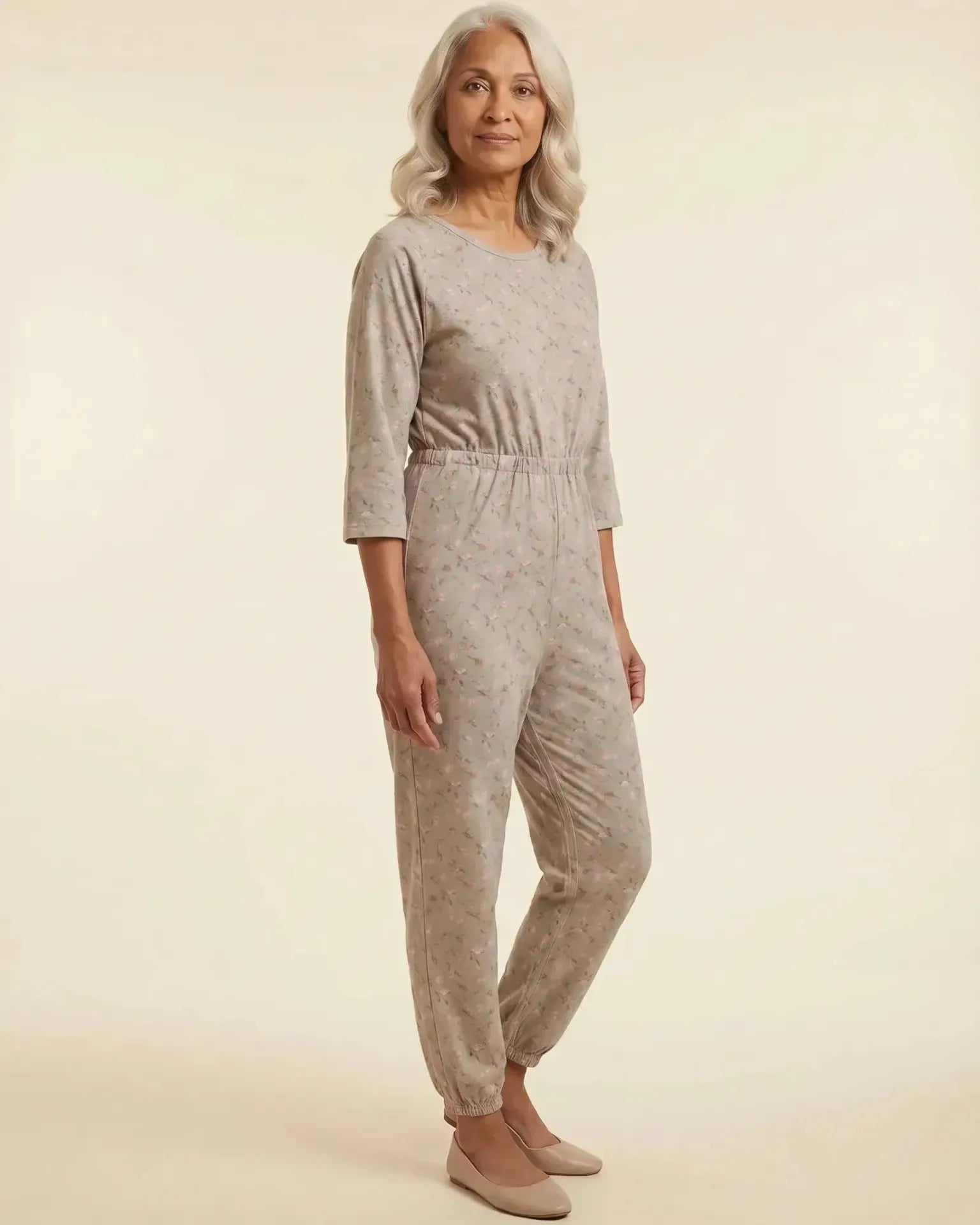 Senior woman wearing Ovidis adaptive Carrie Taupe floral jumpsuit, full body front view