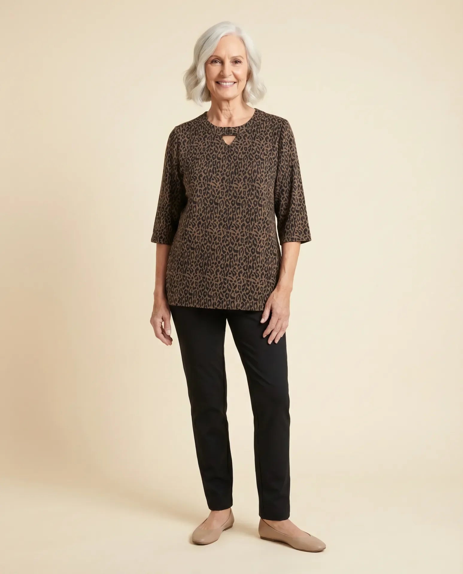 Senior woman wearing adaptive leopard jacquard knit top with keyhole neckline, paired with black pants