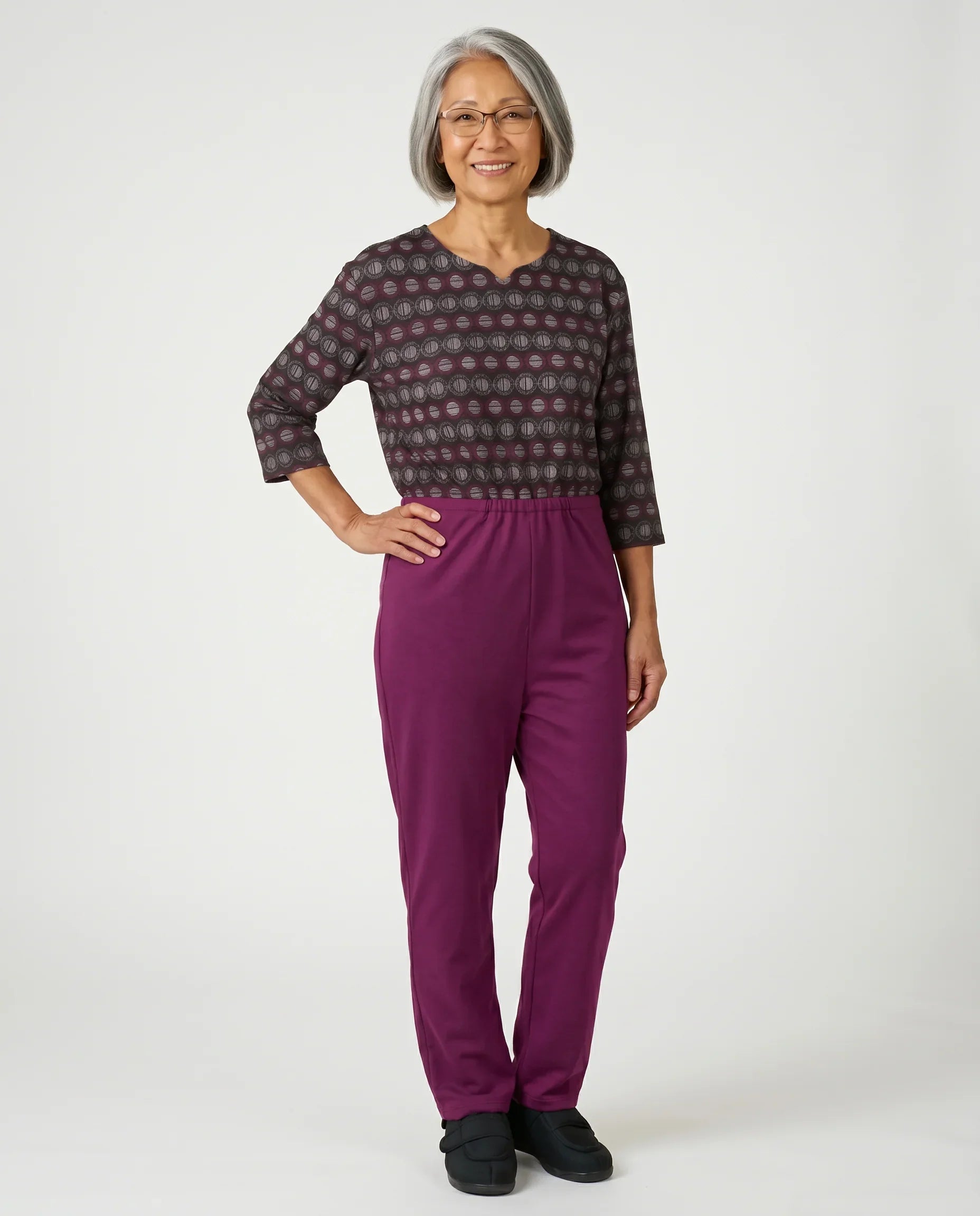 Senior woman wearing Ovidis adaptive Bella Dahlia jumpsuit, full body front view