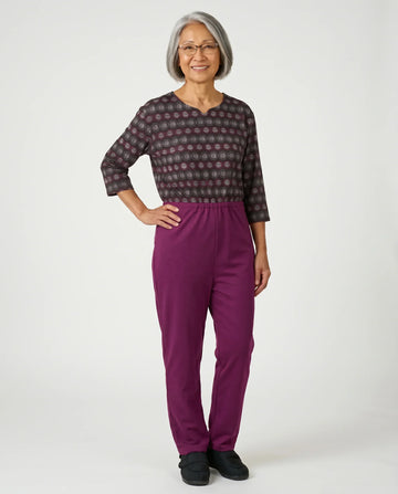 Senior woman wearing Ovidis adaptive Bella Dahlia jumpsuit, full body front view