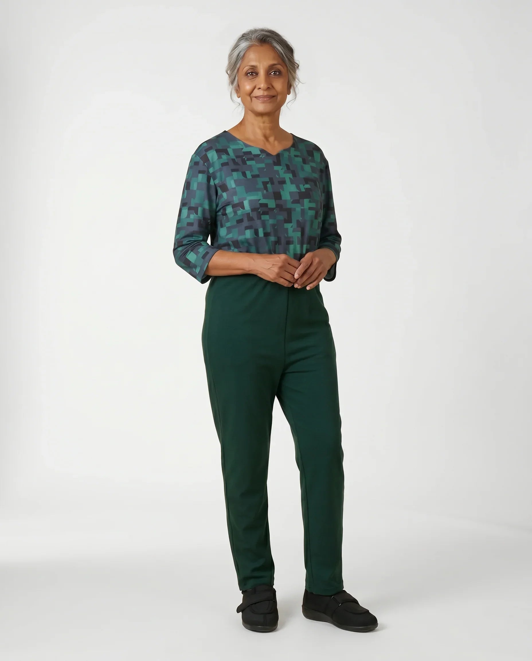 Senior woman wearing Ovidis adaptive Bella Hummingbird jumpsuit, full body front view