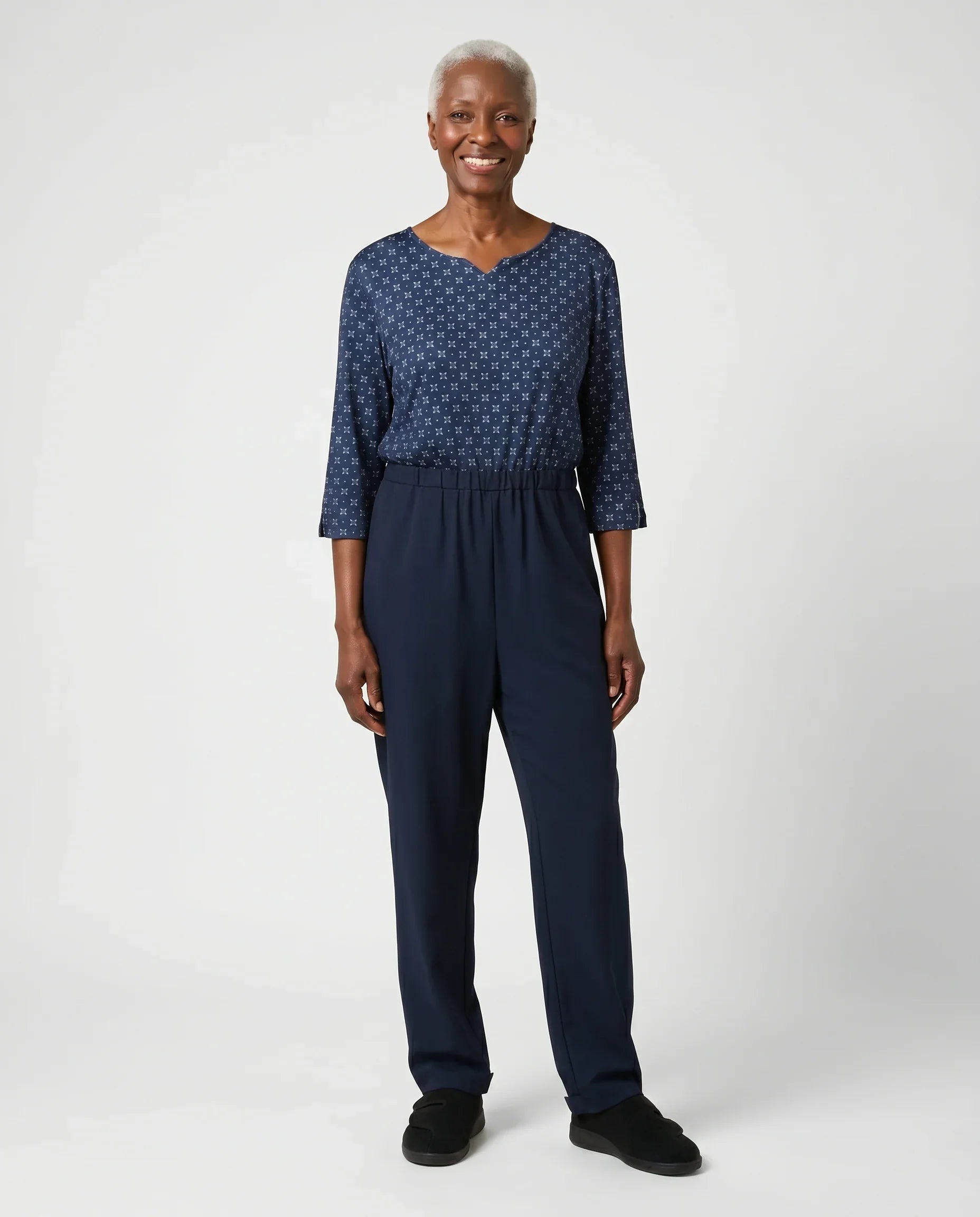 Senior woman wearing Ovidis adaptive Bella Midnight jumpsuit, full body front view