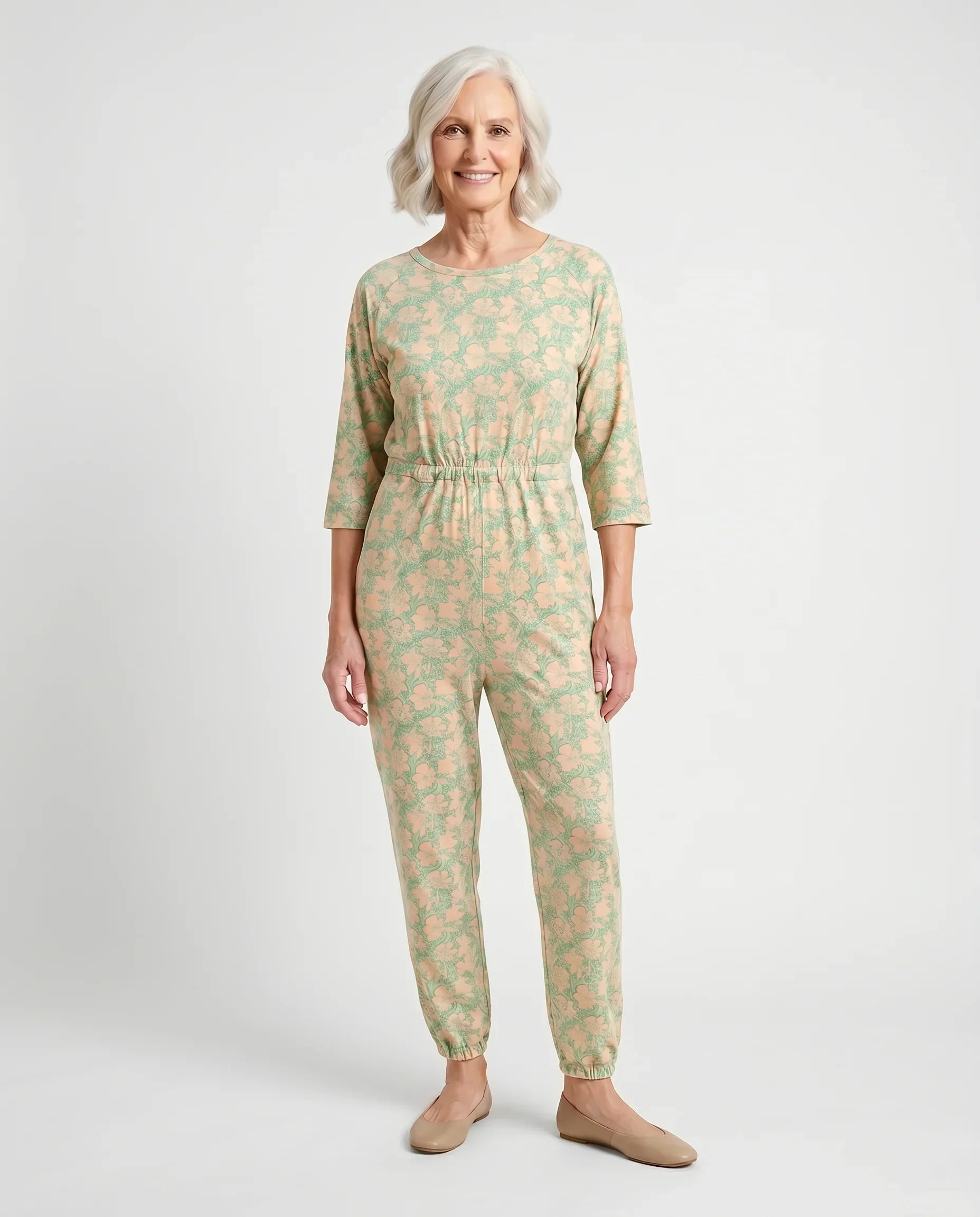 Senior woman wearing Ovidis adaptive Carrie Apple Green floral jumpsuit, full body front view