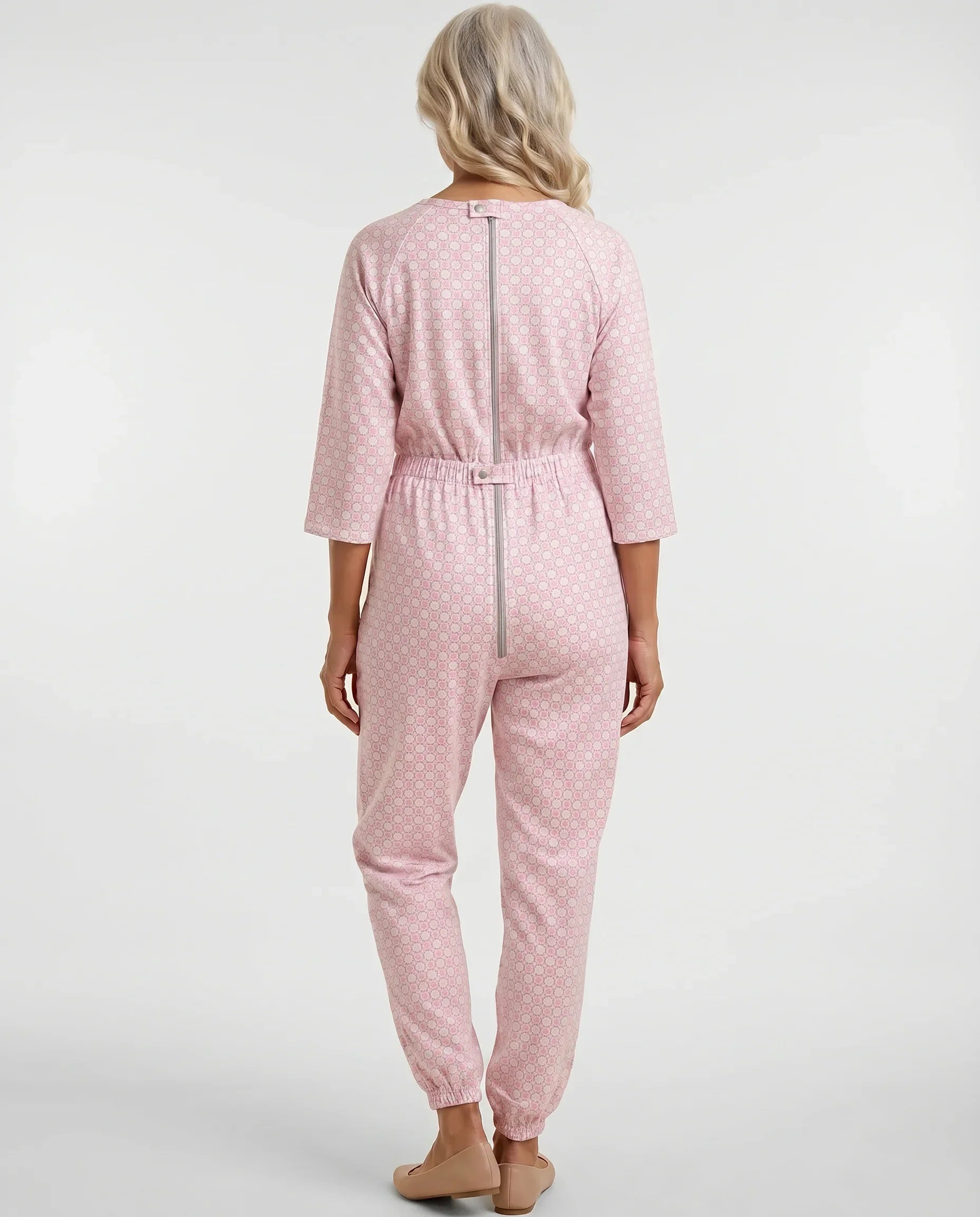 Senior woman wearing Ovidis adaptive Carrie Blush geometric jumpsuit, full body back view showing center-back zipper and snap closure