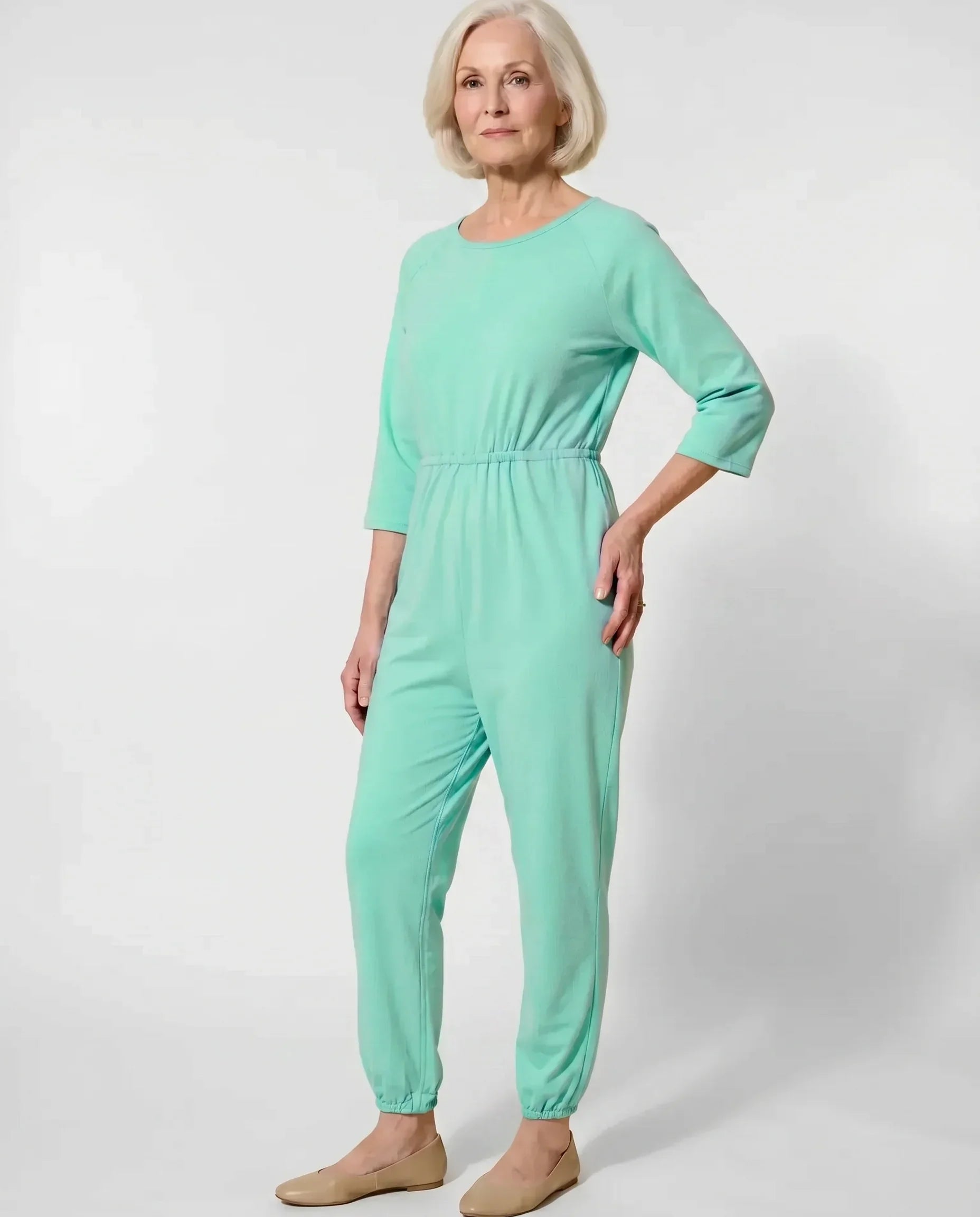 Senior woman wearing Ovidis adaptive Carrie Green jumpsuit, full body front view