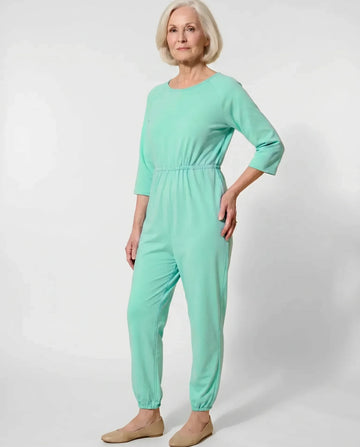 Senior woman wearing Ovidis adaptive Carrie Green jumpsuit, full body front view