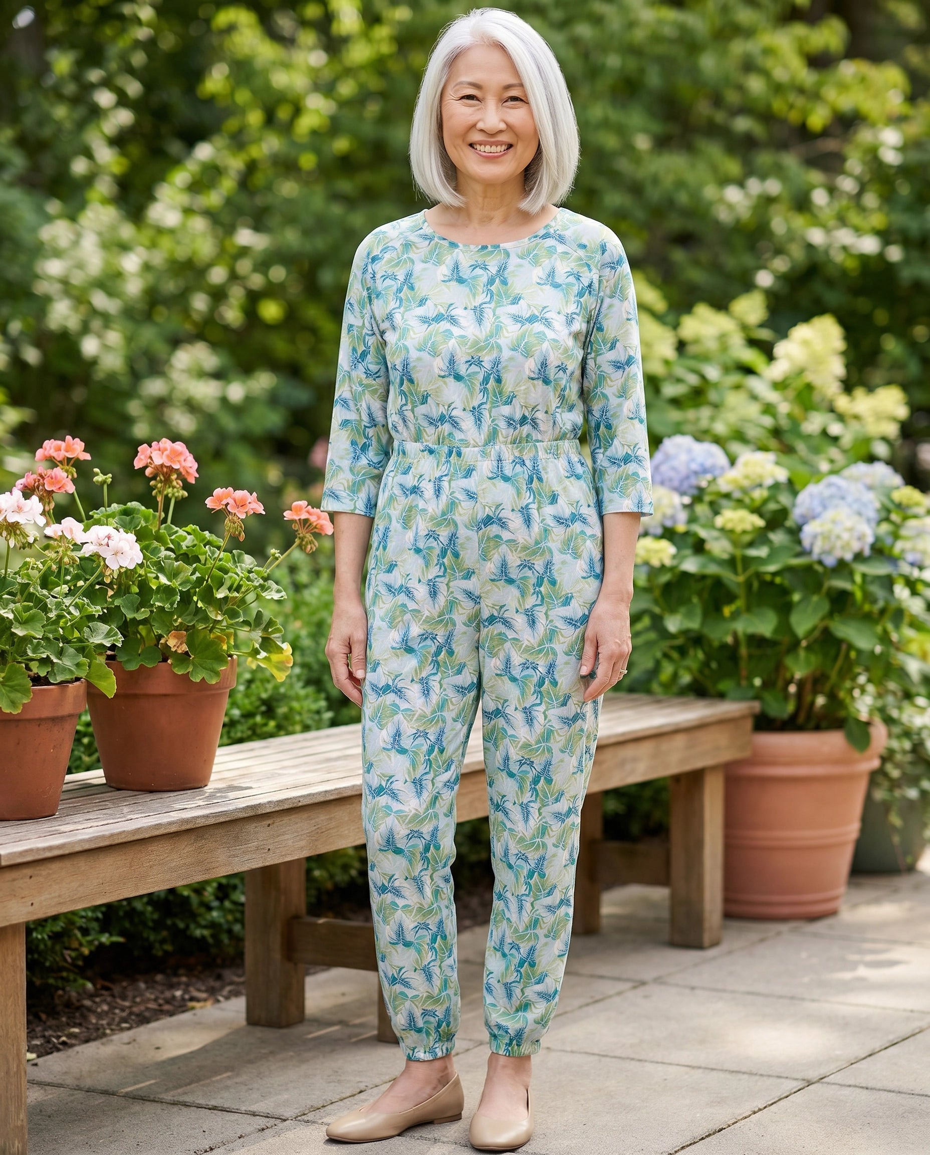 Senior woman wearing Ovidis adaptive Carrie Mint jumpsuit, care facility garden patio lifestyle