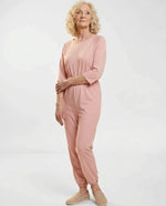 Senior woman wearing Ovidis adaptive Carrie Pink jumpsuit, full body front view