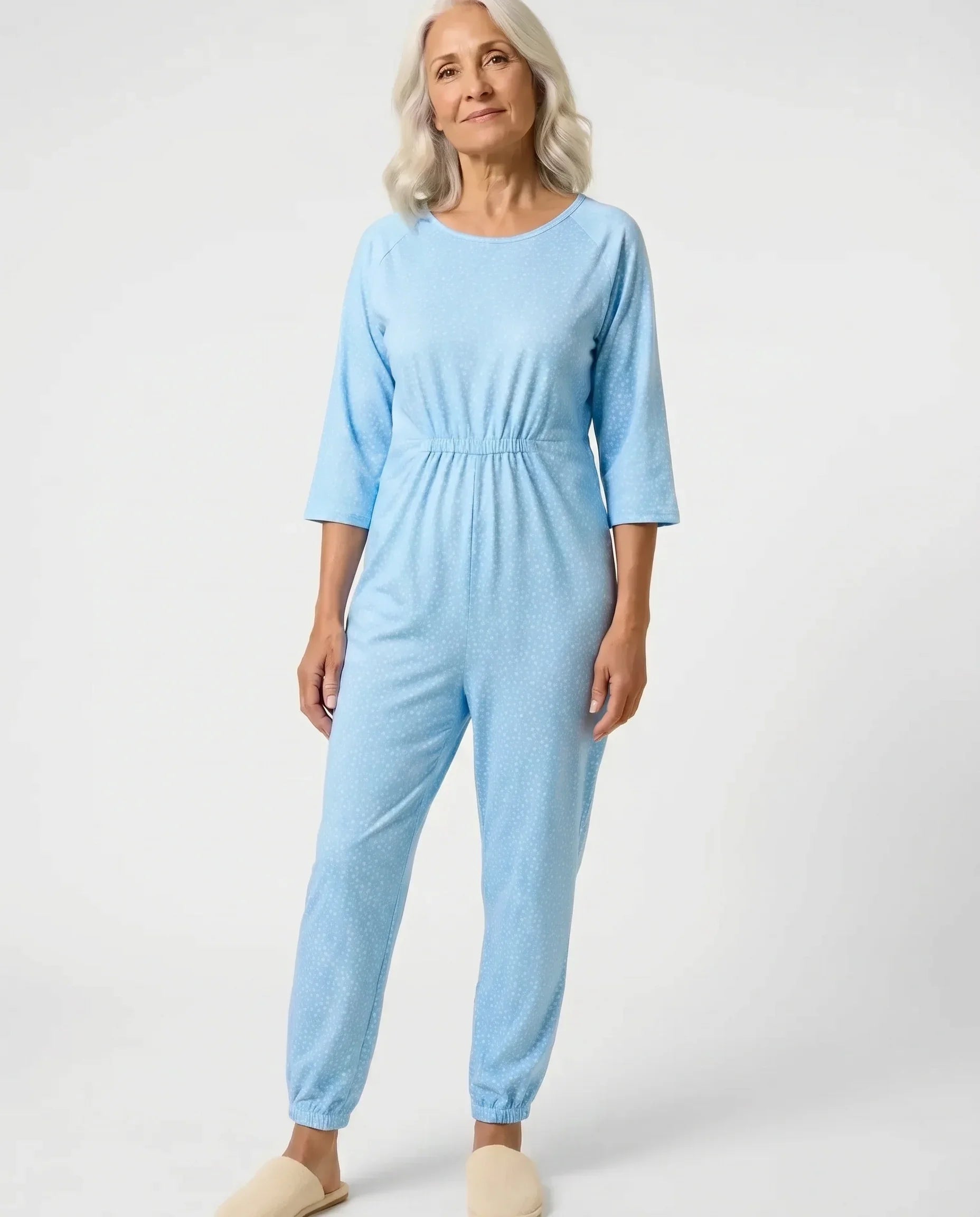 Senior woman wearing Ovidis adaptive Carrie Sky jumpsuit, full body front view