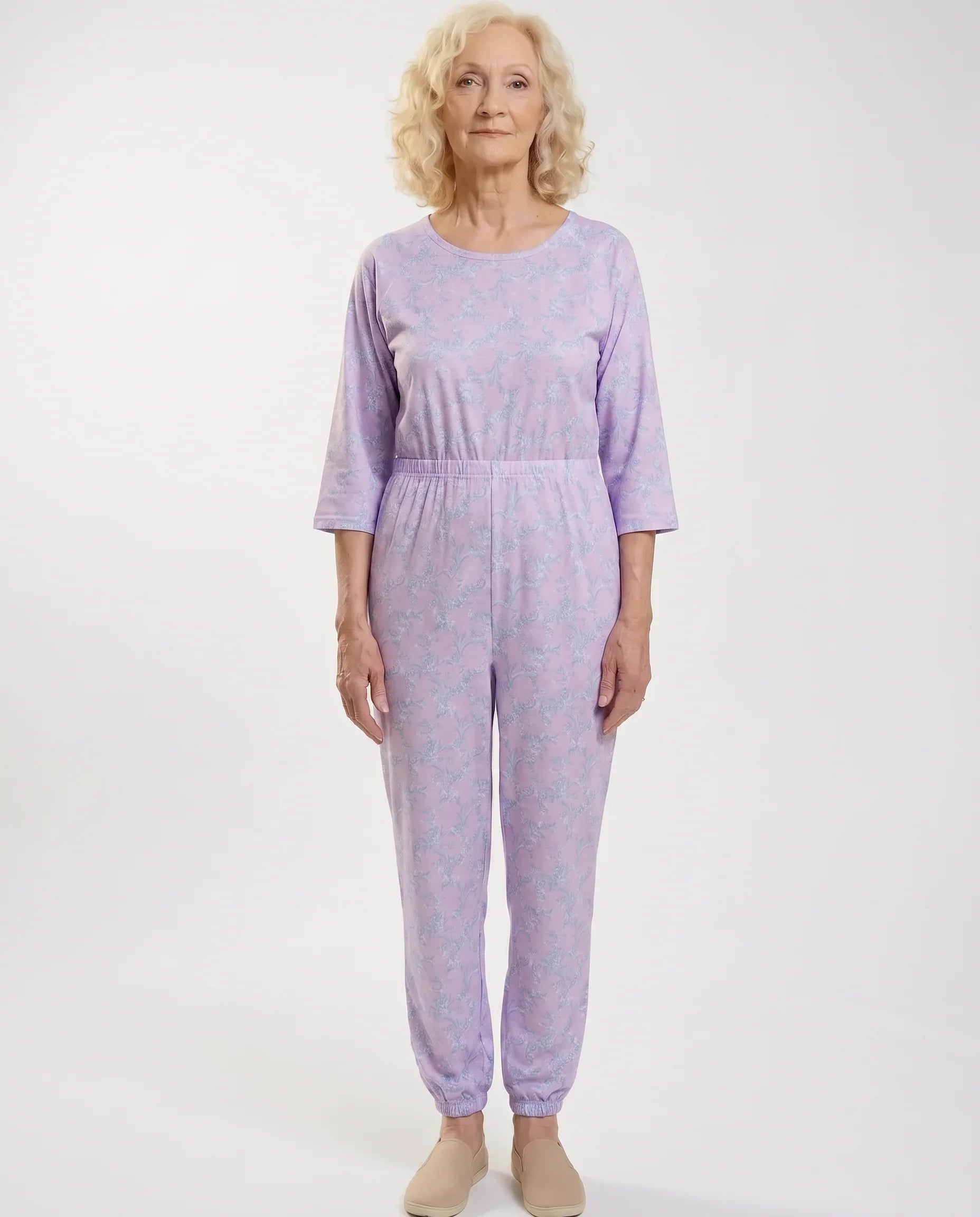 Senior woman wearing Ovidis adaptive Carrie Wisteria jumpsuit, full body front view