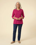 Senior woman wearing Ovidis adaptive raspberry top with stud button detail, easy dressing