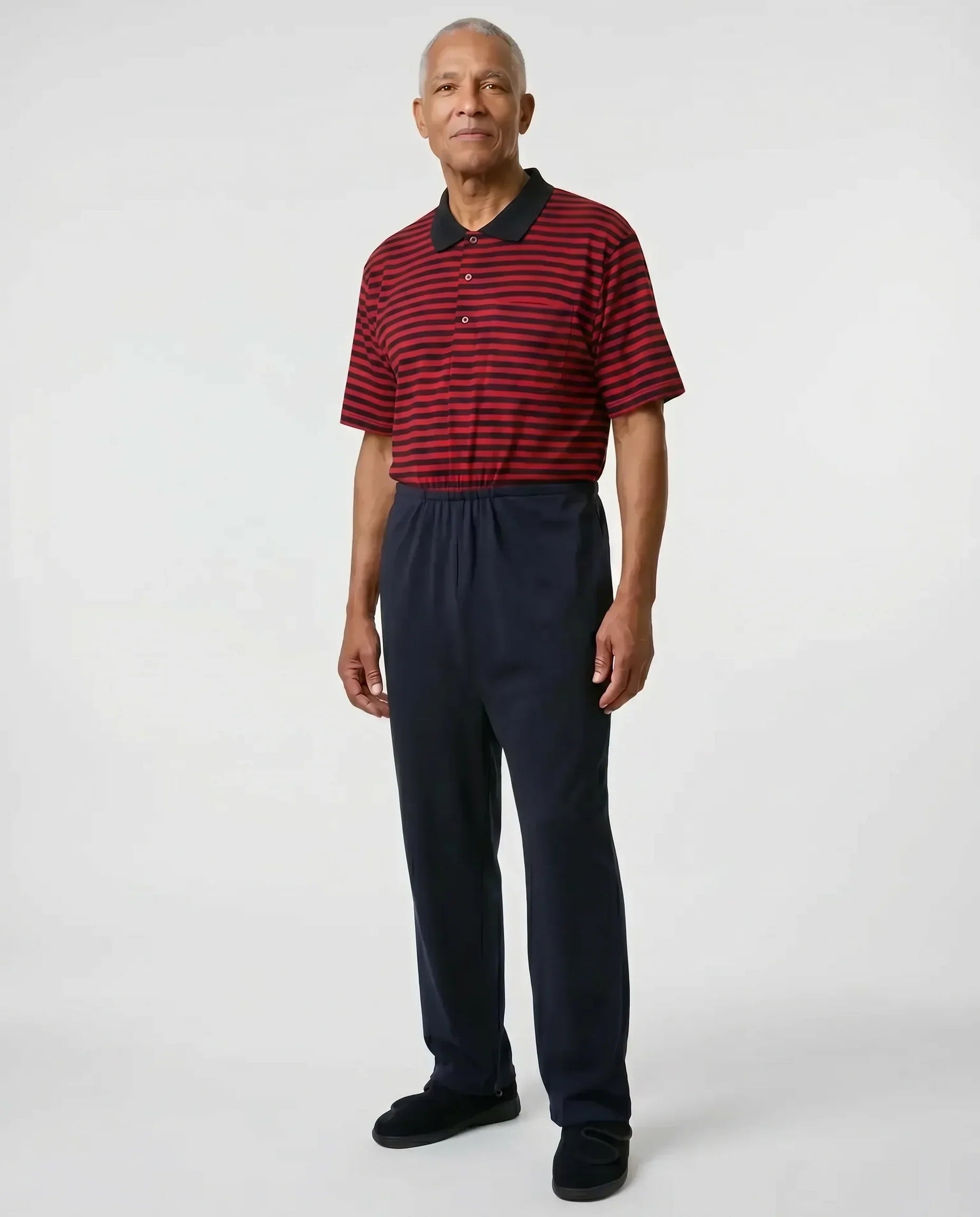 Senior man wearing Charly Red adaptive jumpsuit — red and black stripe polo top with dark navy pants