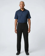 Senior man wearing Charly Twilight adaptive jumpsuit — deep midnight navy micro-pattern polo top with black pants