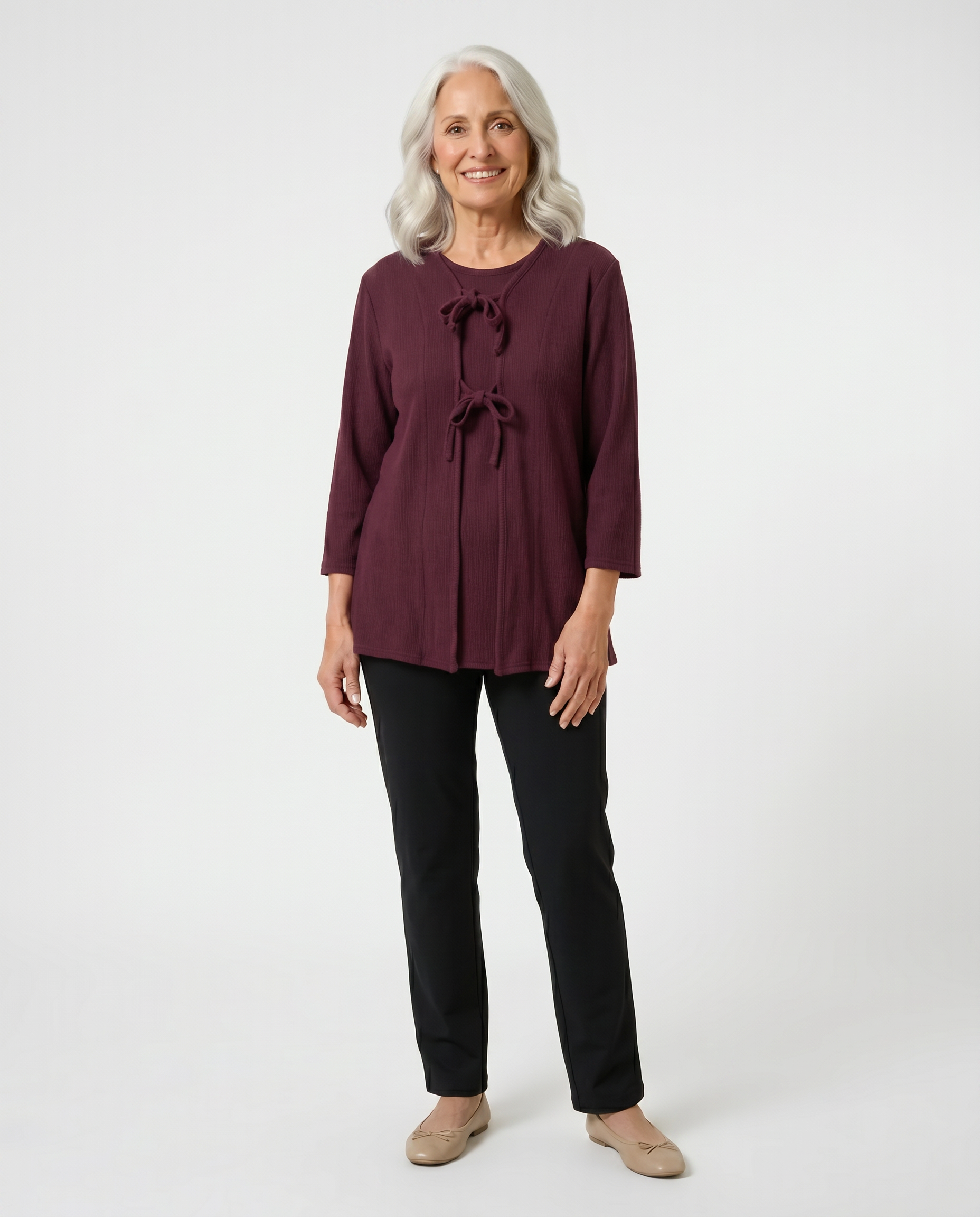 Senior woman wearing adaptive burgundy cable-knit top with front self-tie closures, paired with black pants