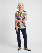 Senior woman wearing Ovidis adaptive olive botanical floral top with contrast Y-insert, easy dressing
