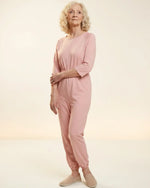 Senior woman wearing Ovidis adaptive Carrie Pink jumpsuit, full body front view