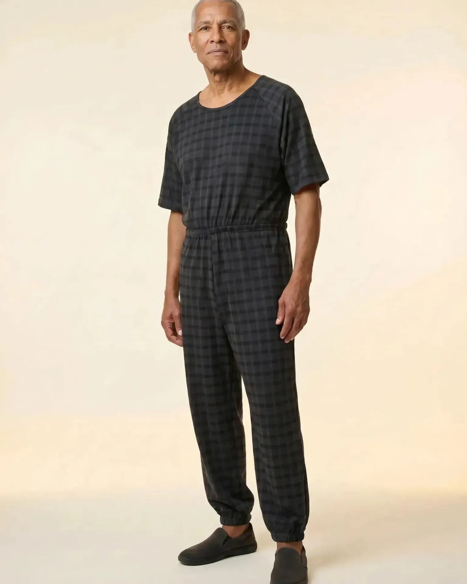 Senior man wearing Ovidis adaptive Bobby Black Check jumpsuit, full body front view