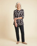 Senior woman wearing Ovidis adaptive black floral knit top with feminine sleeve detail, easy dressing