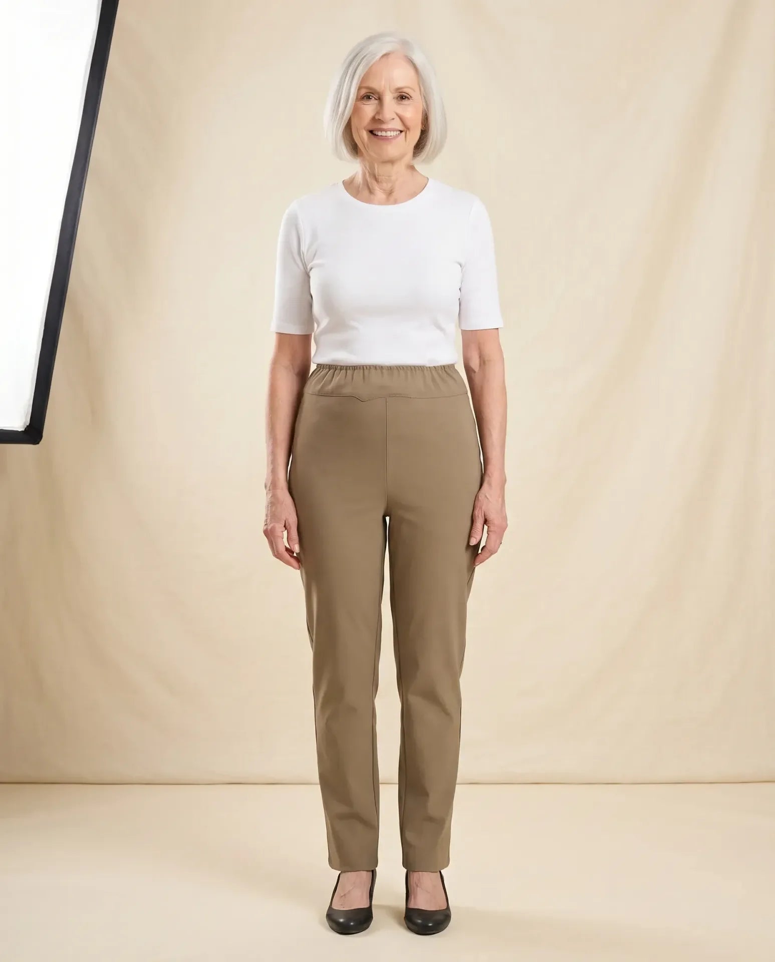 Senior woman wearing Ovidis Sara Pants in Tan, full body front view