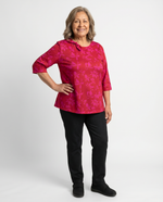 Senior woman wearing Ovidis adaptive fuchsia floral top with bow neckline detail, easy dressing