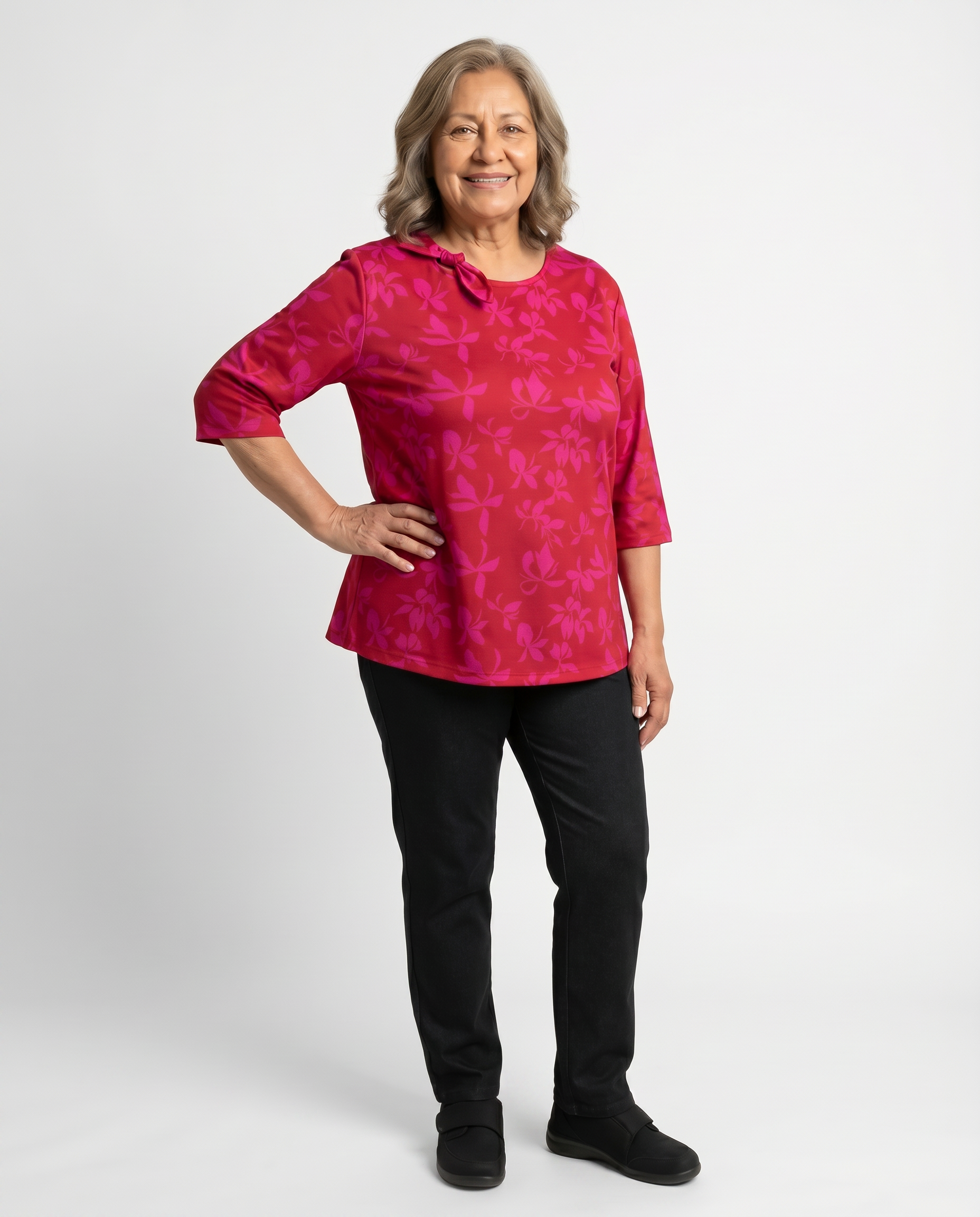 Senior woman wearing Ovidis adaptive fuchsia floral top with bow neckline detail, easy dressing