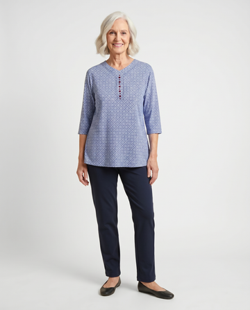 Senior woman wearing Ovidis adaptive blue daisy print top with burgundy button detail, easy dressing