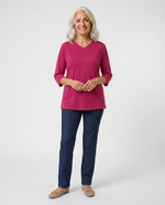 Senior woman wearing Ovidis adaptive raspberry top with stud button detail, easy dressing