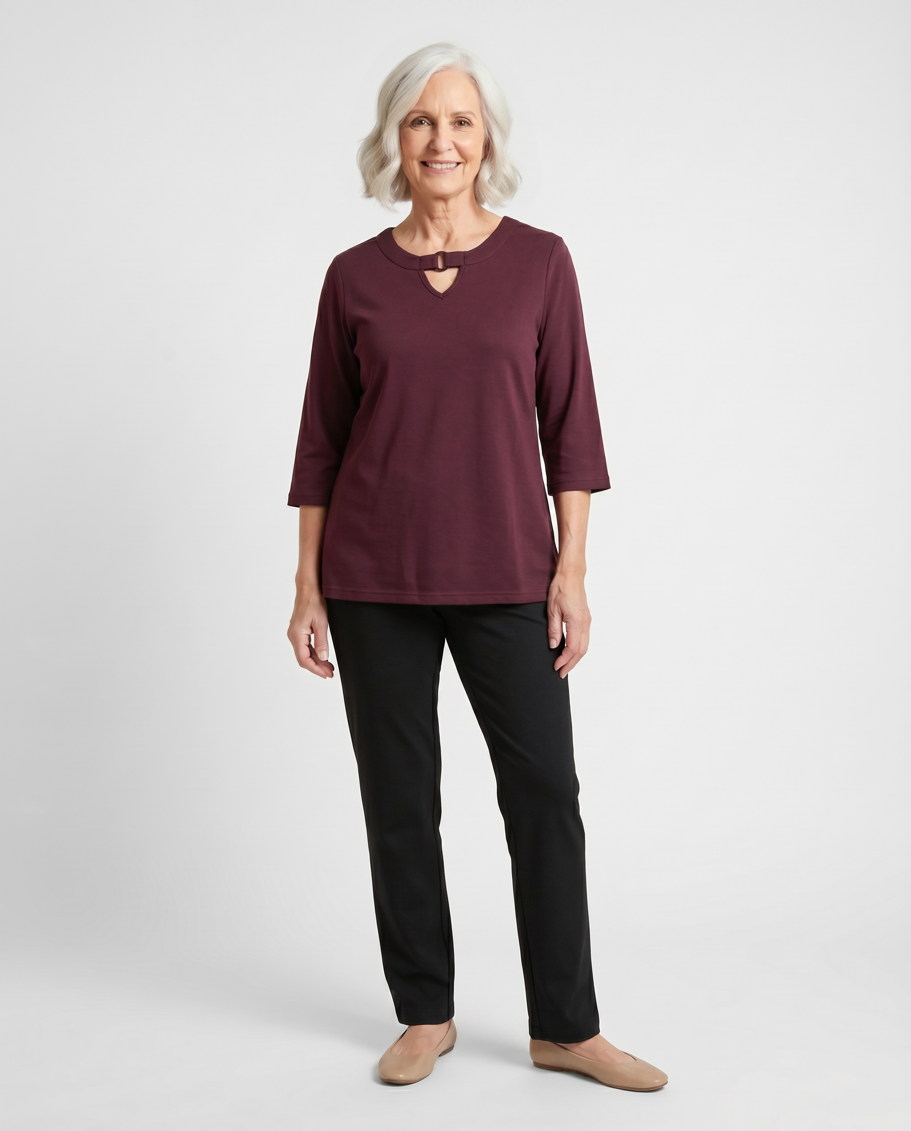 Senior woman wearing adaptive burgundy knit top with keyhole ring neckline detail, paired with black pants