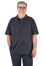 Man wearing Ovidis adaptive black check short sleeve shirt for seniors, standing and smiling.