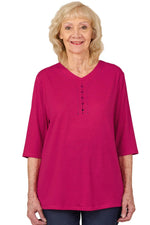 Senior woman wearing Ovidis adaptive Layla top in watermelon pink, front view