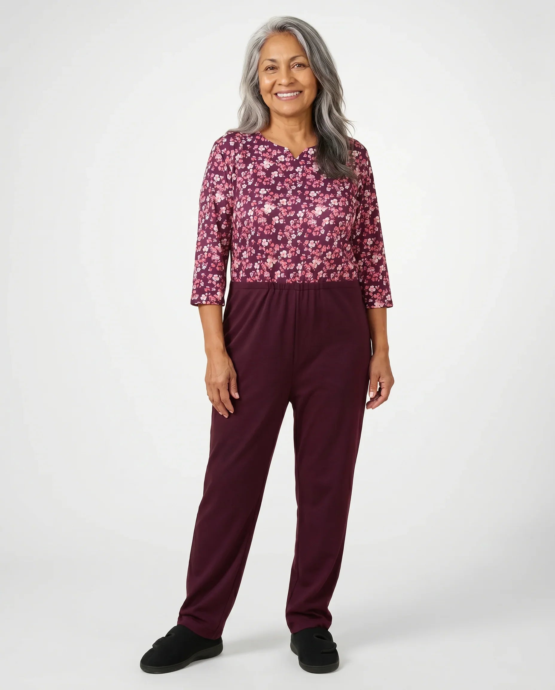 Senior woman wearing Ovidis adaptive Sia Rosewood jumpsuit, full body front view