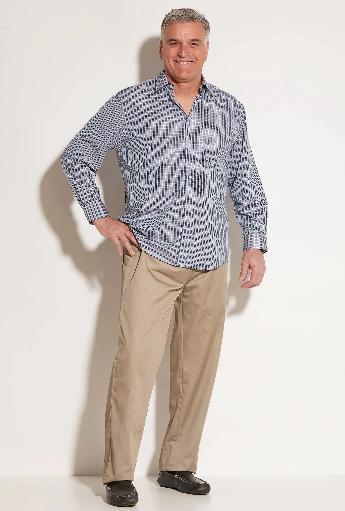 Senior man modeling blue checkered adaptive long sleeve shirt and beige pants